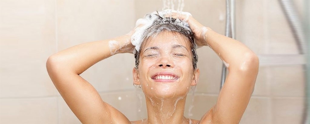 Mujer feliz lavándose el cabello