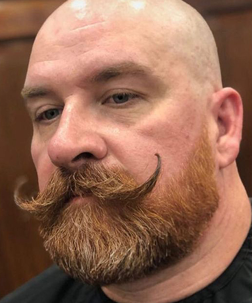 Hombre calvo fuertudo con bigote van dyke